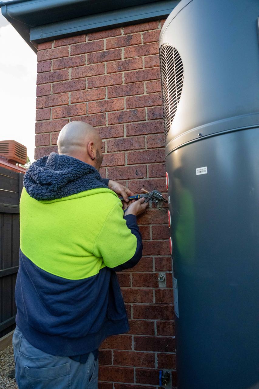 Goldsure installer working on a heat pump hot water system